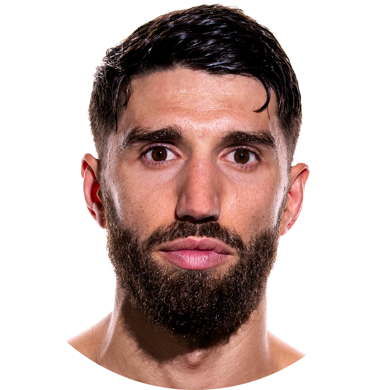 Portrait of a man with a beard and short dark hair, neutral expression.