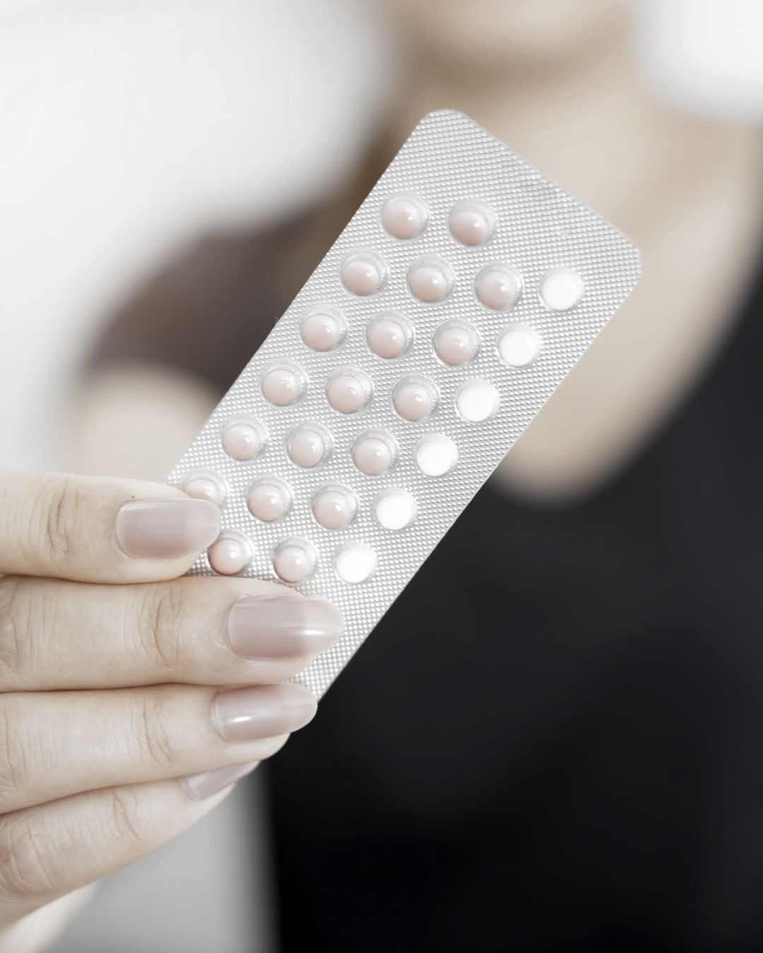 Close-up of a hand holding a blister pack of pills.