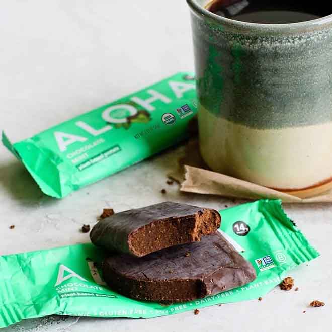Protein bar and ceramic mug of coffee on a table.