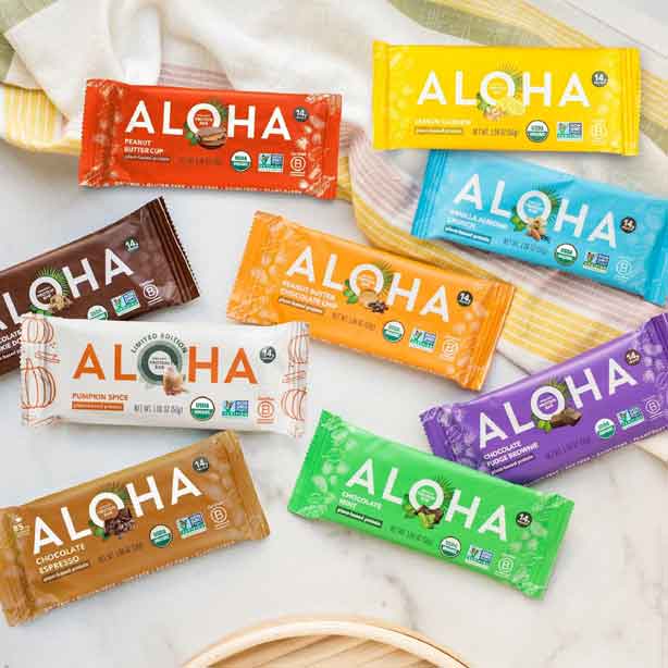 Assorted Aloha protein bars in colorful packaging on a light background.