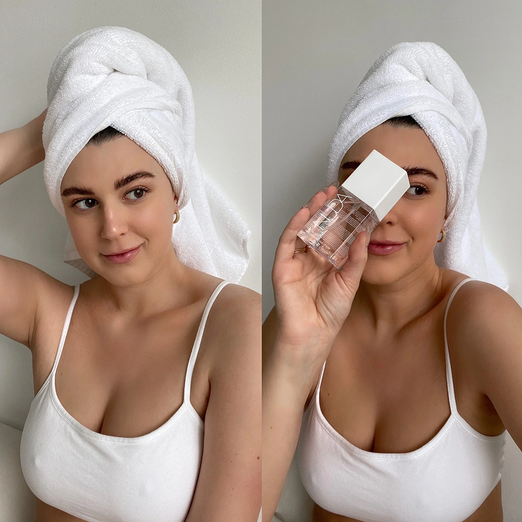 Woman with towel on head, holding a perfume bottle.