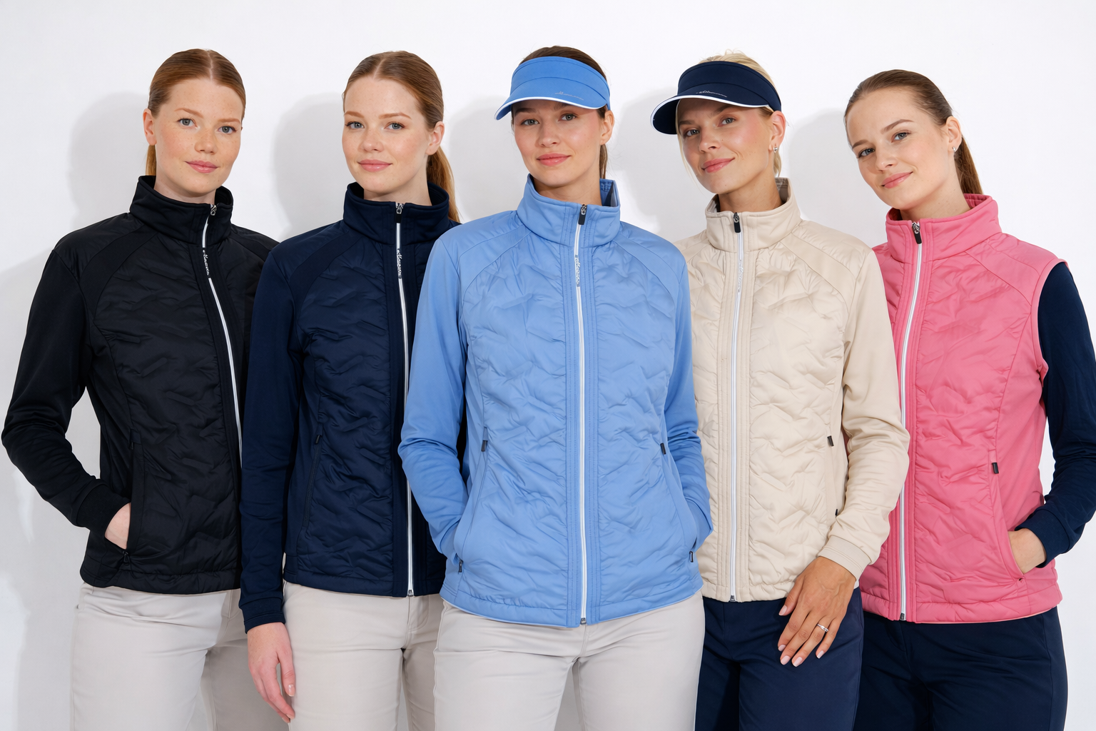 Five women wearing different colored quilted athletic jackets and vests stand against a white background.