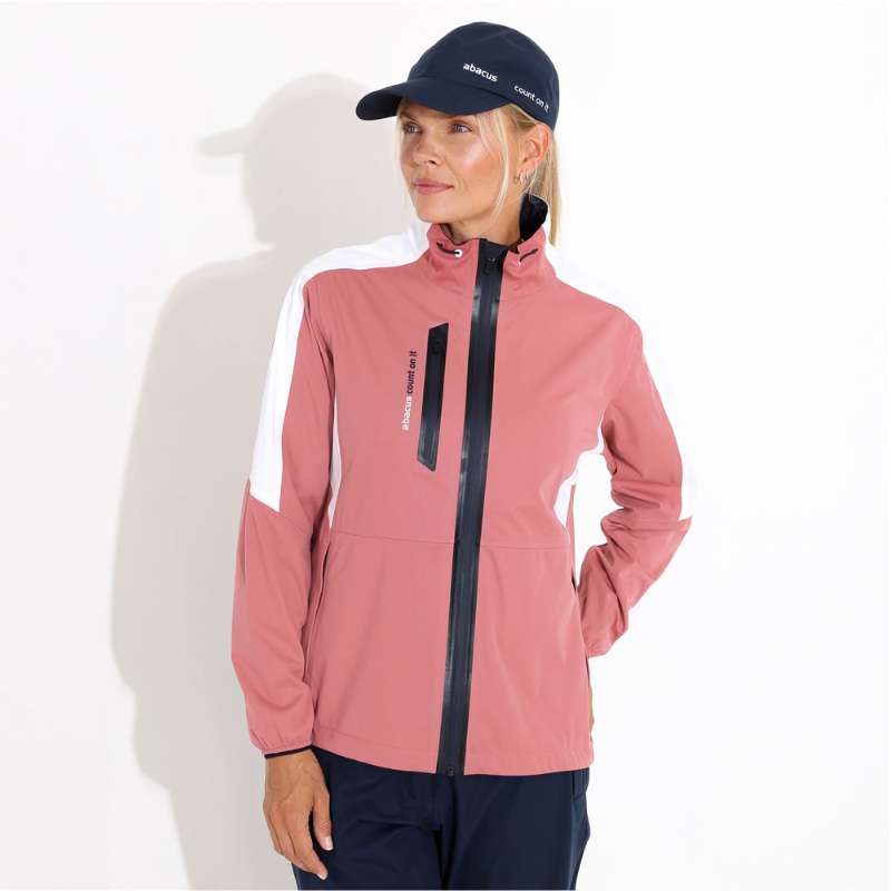 A woman wearing a pink, white, and black zip-up jacket with a blue baseball cap.