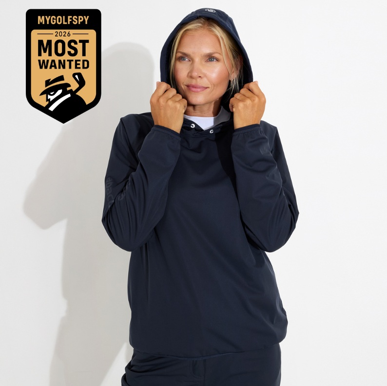 A woman with blonde hair models a dark blue hooded sweatshirt, holding the hood with her hands.