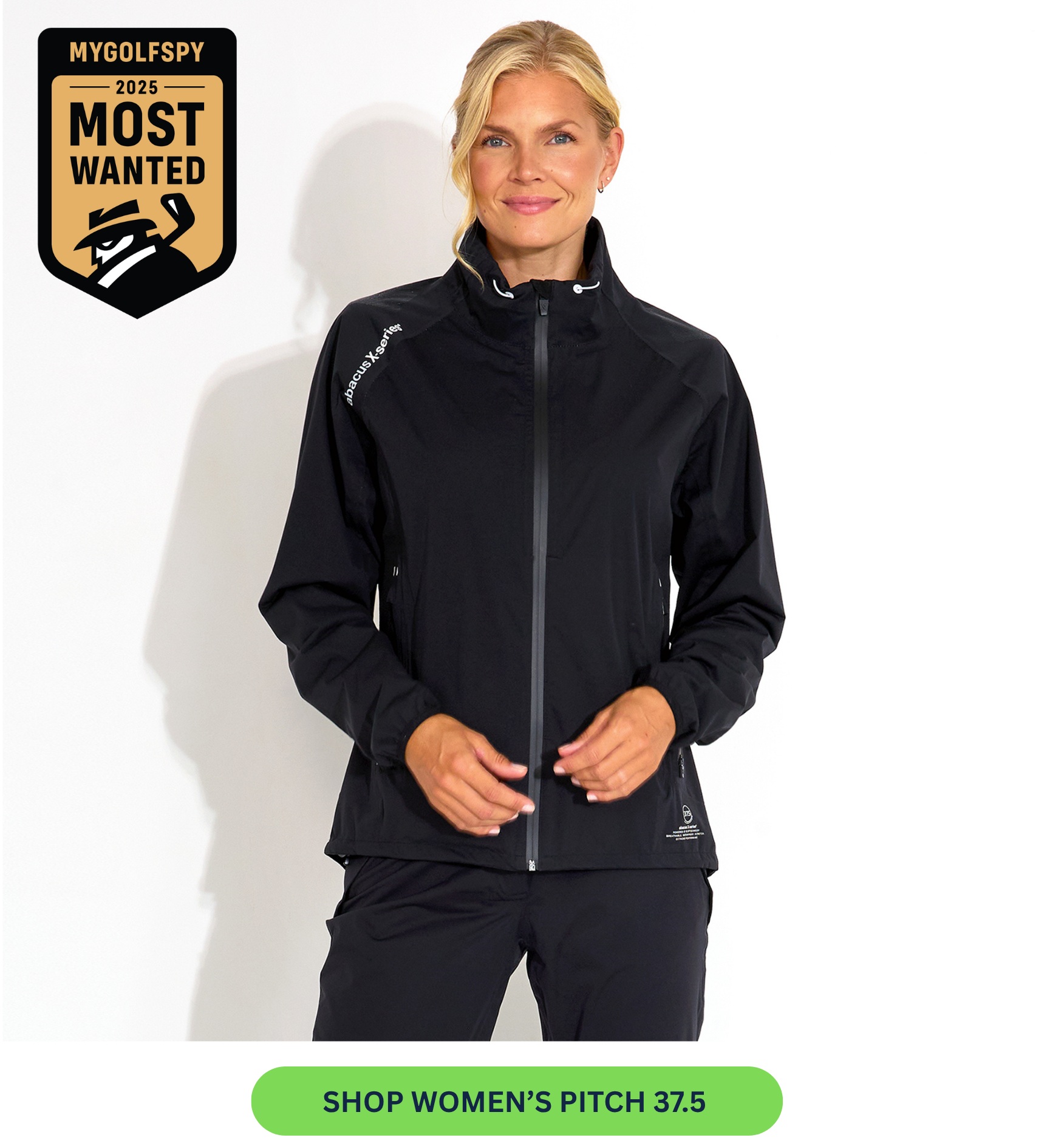 A woman with blonde hair models a black zip-up jacket and matching pants against a white background.