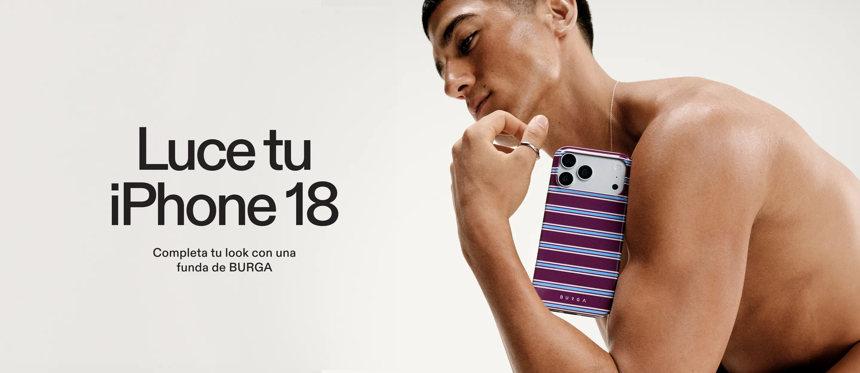 A shirtless man holding an iPhone in a purple, blue, and white striped case.