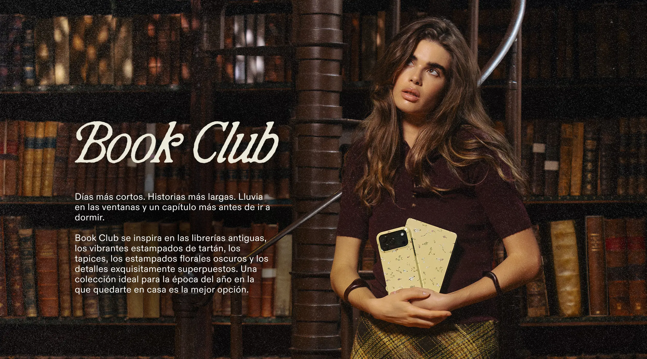 A woman with long hair stands in a library holding two patterned phone cases.