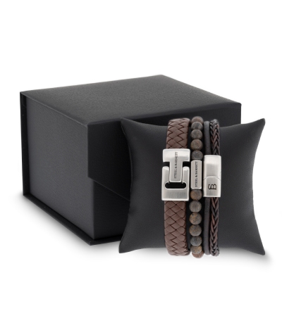 A black box containing two bracelets and a leather pouch, arranged neatly for display.