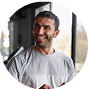 Smiling man in a gym wearing a gray shirt.