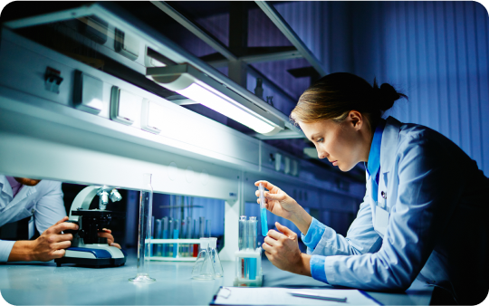 Scientist in a lab coat working with test tubes in a laboratory.