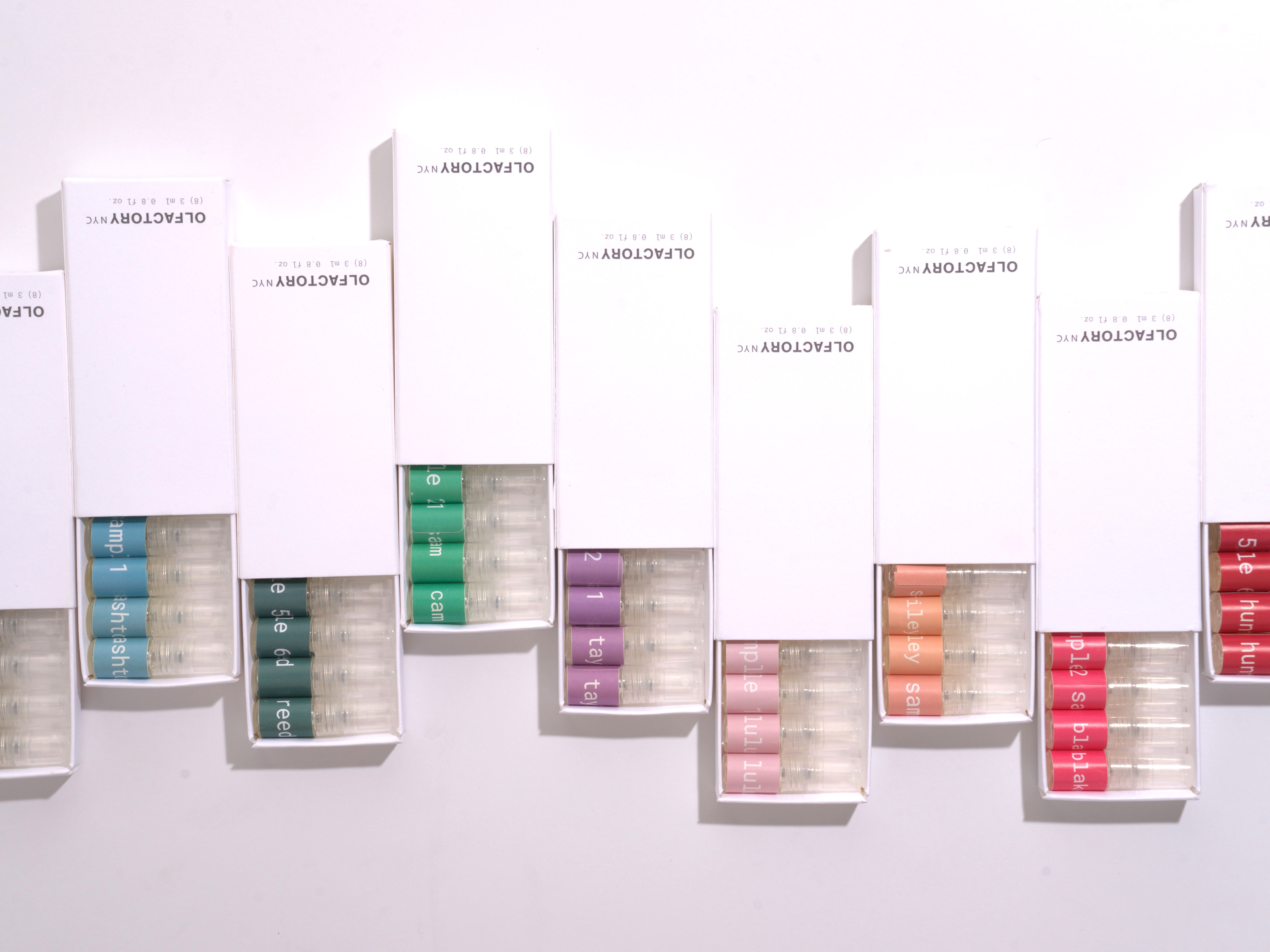 Five boxes with colorful cylindrical objects inside against a white background.