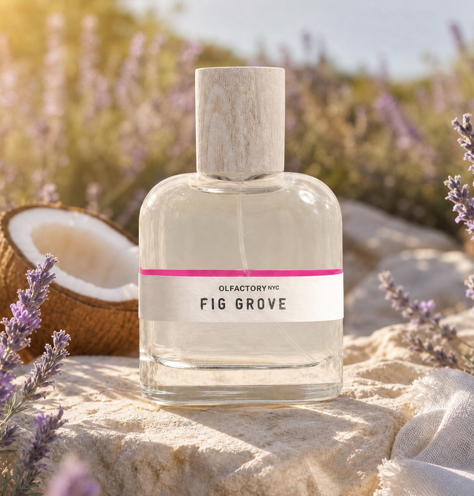 A bottle of Olfactory NYC's Fig Grove perfume sits on a rock with lavender and a coconut.