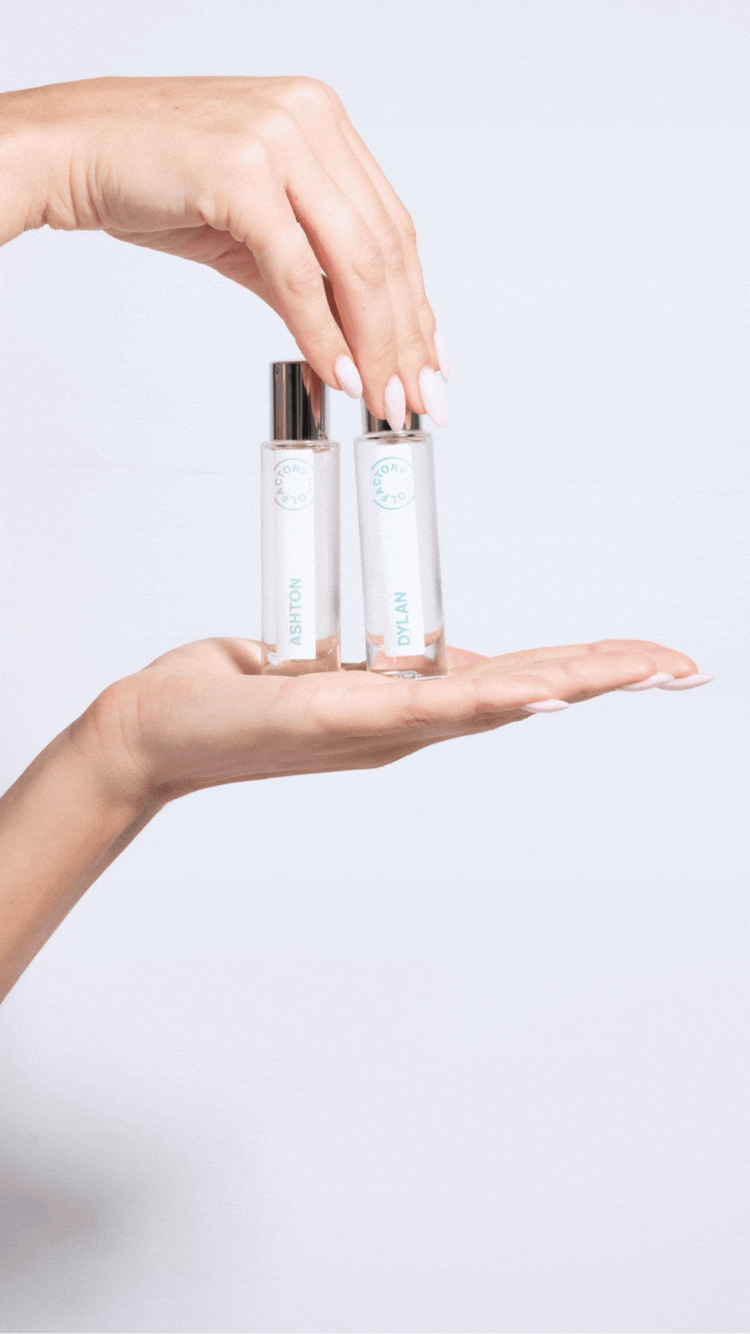 Two hands holding small perfume bottles labeled Ashton and Dylan.