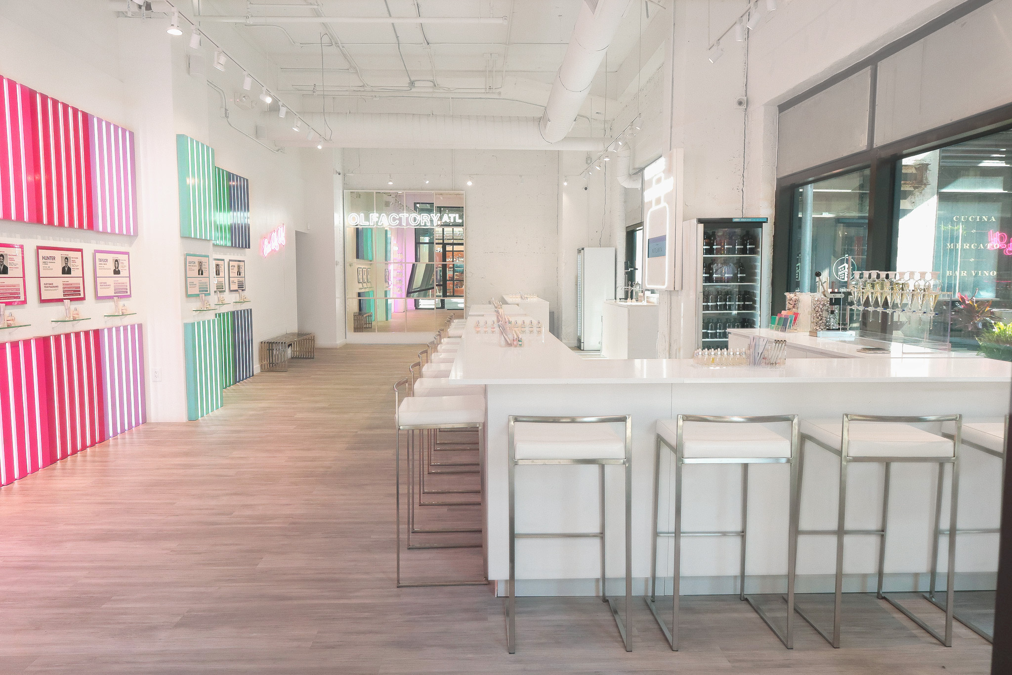 Modern, bright interior with white counters, stools, and colorful wall panels.