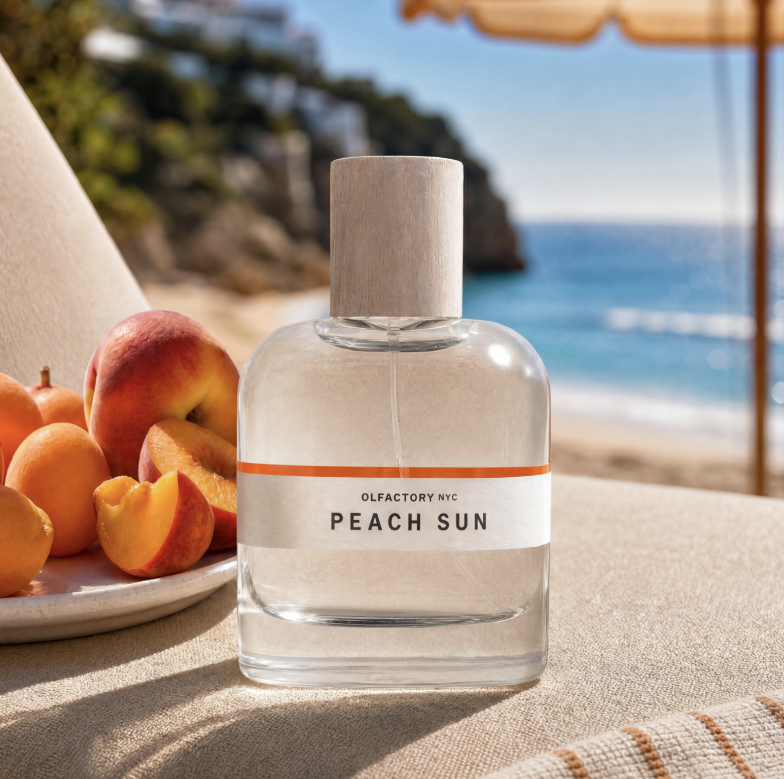 A bottle of Peach Sun perfume sits next to a plate of fresh peaches on a sunny beach.