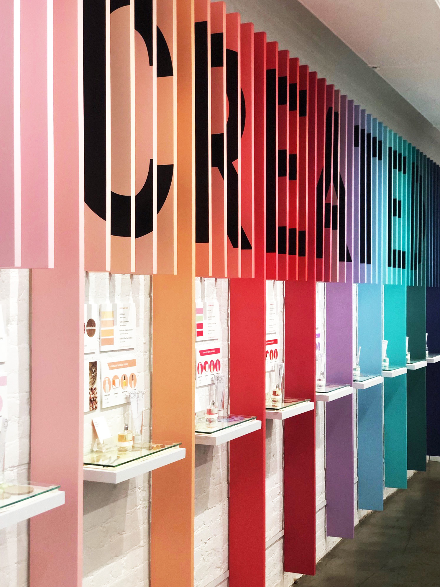 Colorful vertical panels spelling 'CREATE' with display shelves underneath.