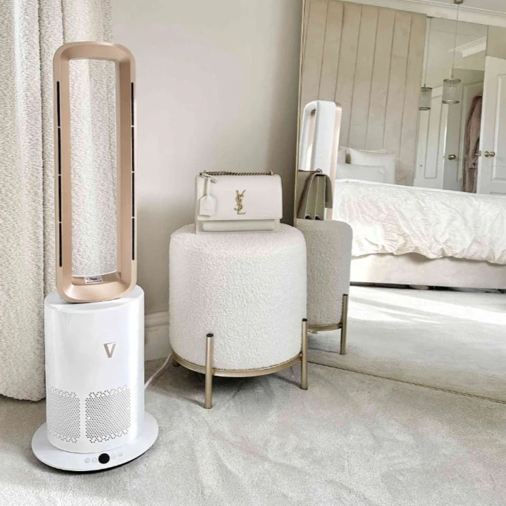 Modern fan and small white stool with a purse in a bedroom.