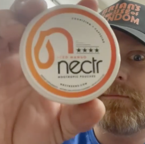 Person holding a container labeled 'nectr' with a logo and text.