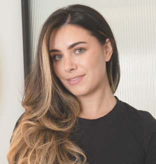 Person with long hair smiling in front of a translucent background.