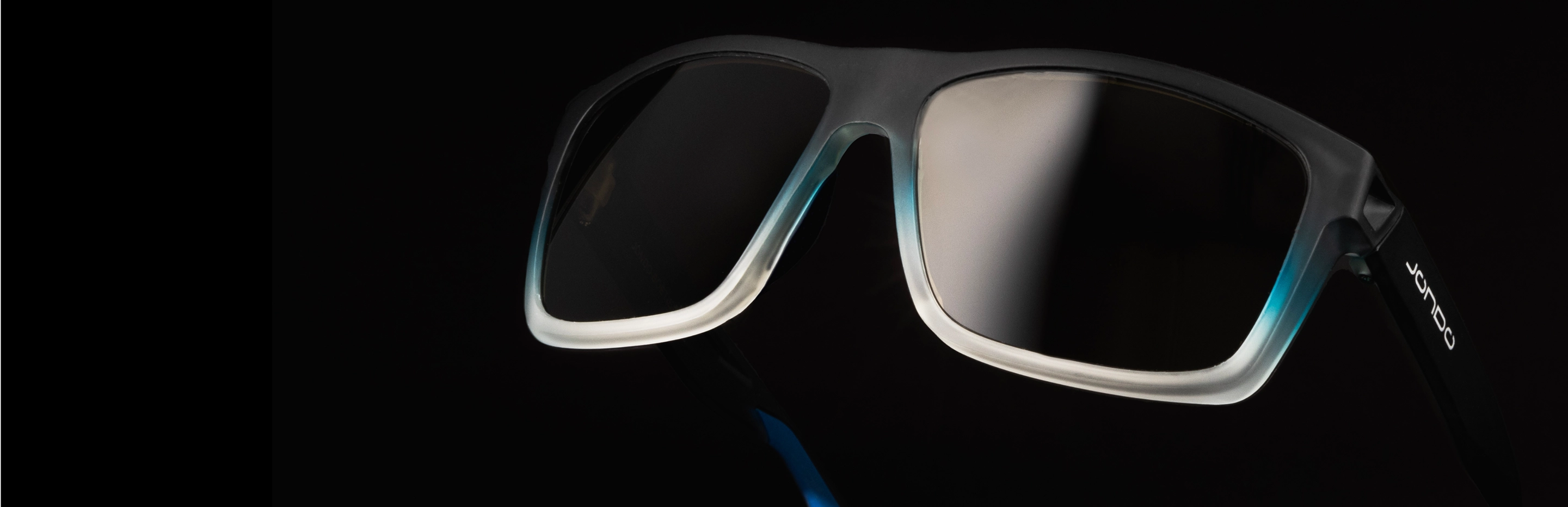Close-up of black sunglasses with gradient blue and white frame on a dark background.