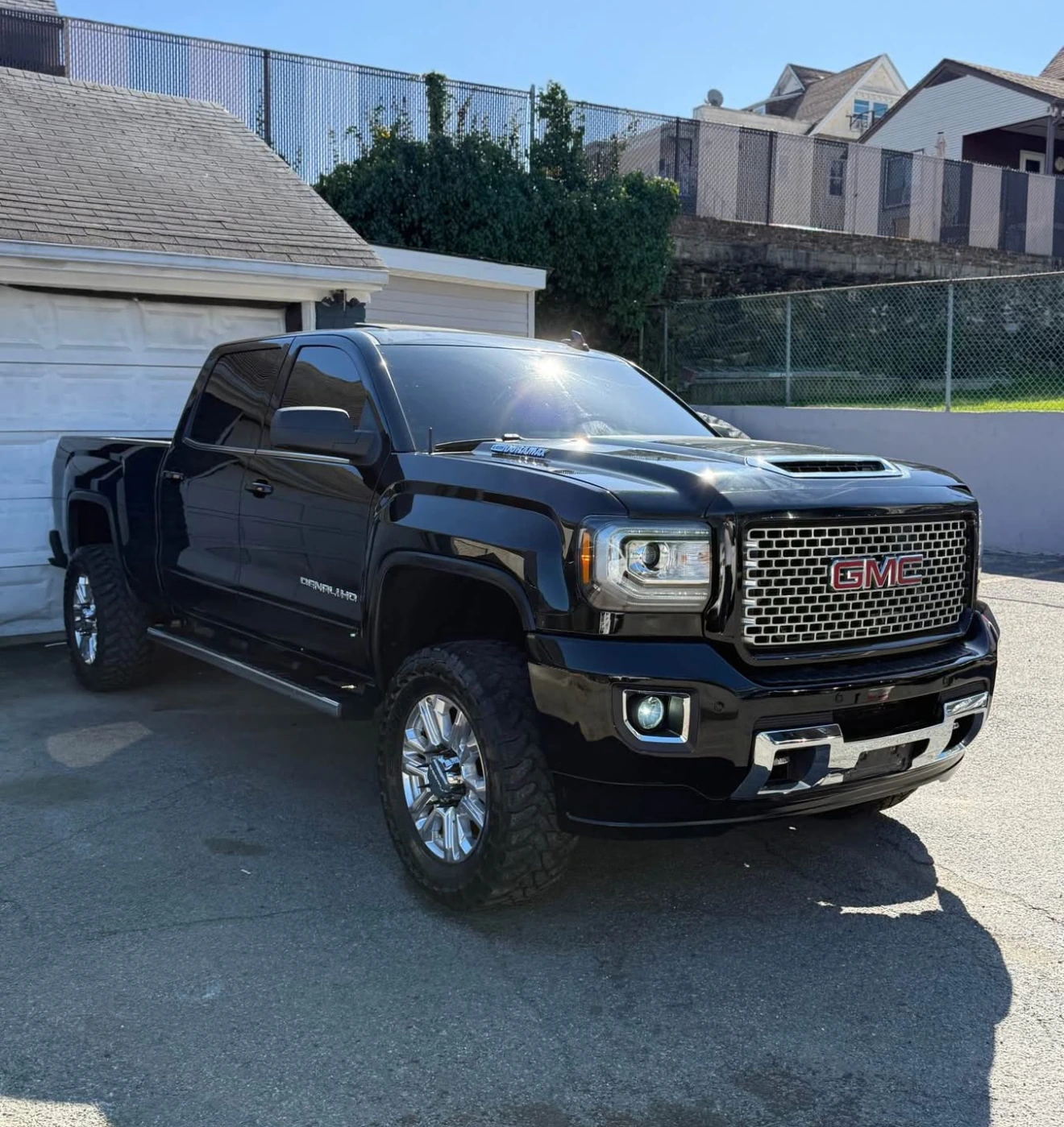 Black GMC truck parked in front of a garage.