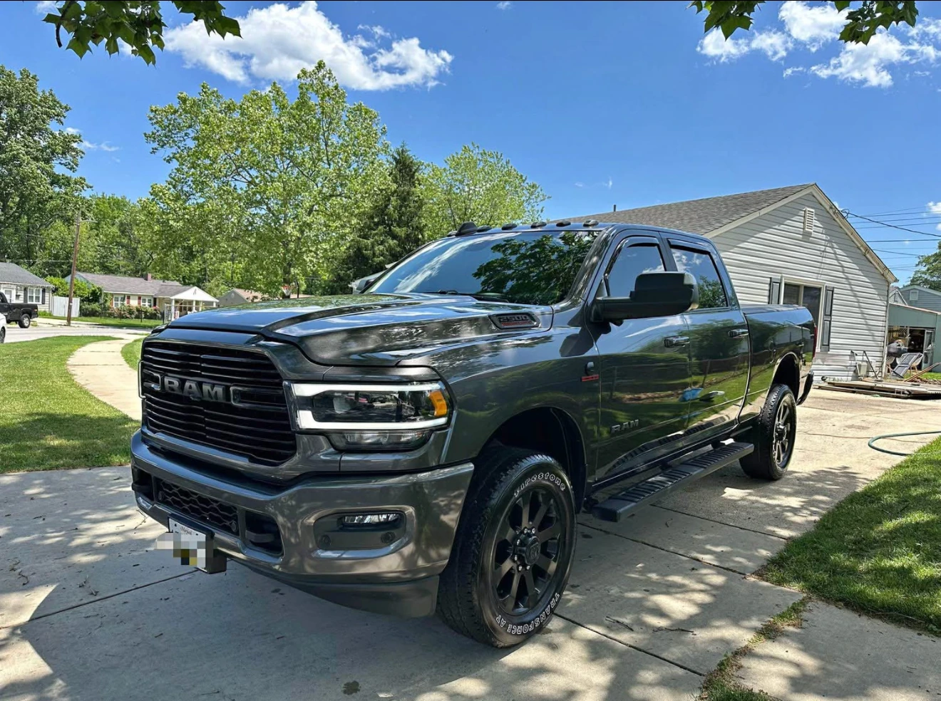 Gray pickup truck parked in a driveway on a sunny day.