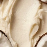 A close-up of a thick, creamy white substance swirled around pieces of coconuts.