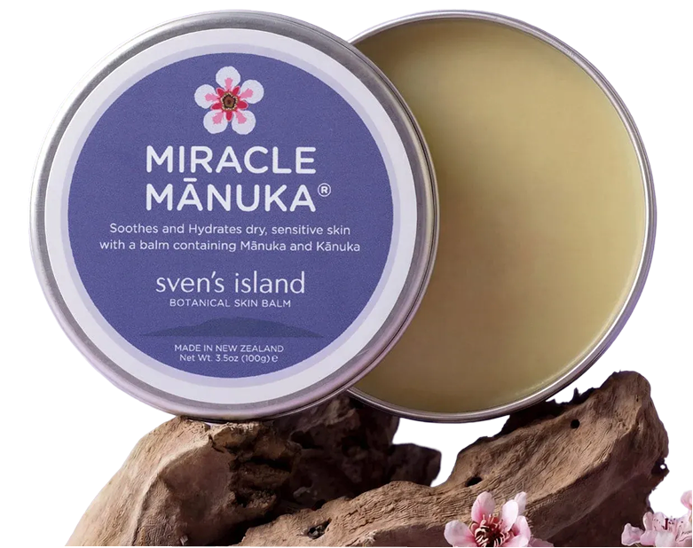 An open tin of Sven's Island Miracle Mānuka botanical skin balm resting on a piece of driftwood.