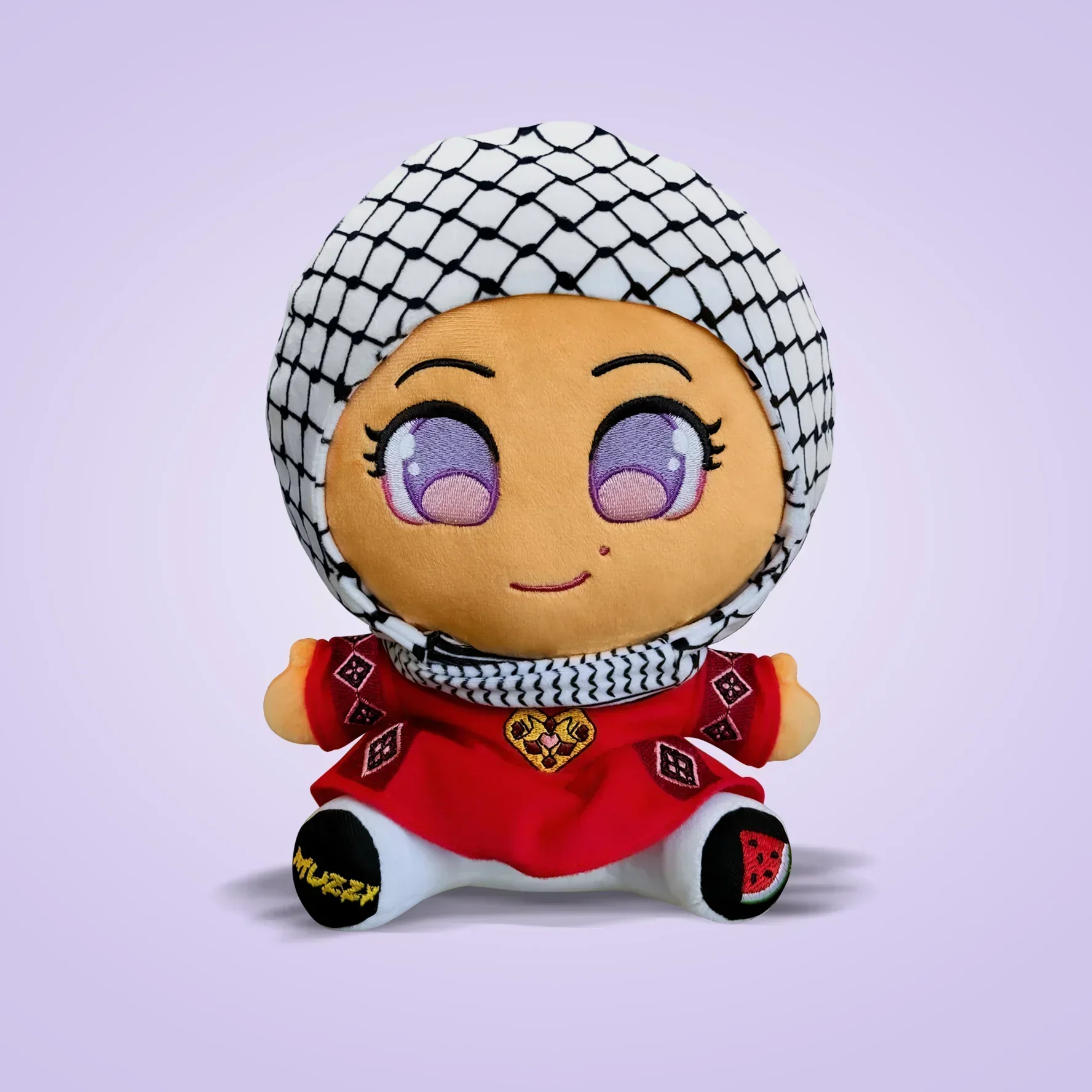 A plush doll with large purple eyes wearing a red dress and a black and white keffiyeh headscarf.
