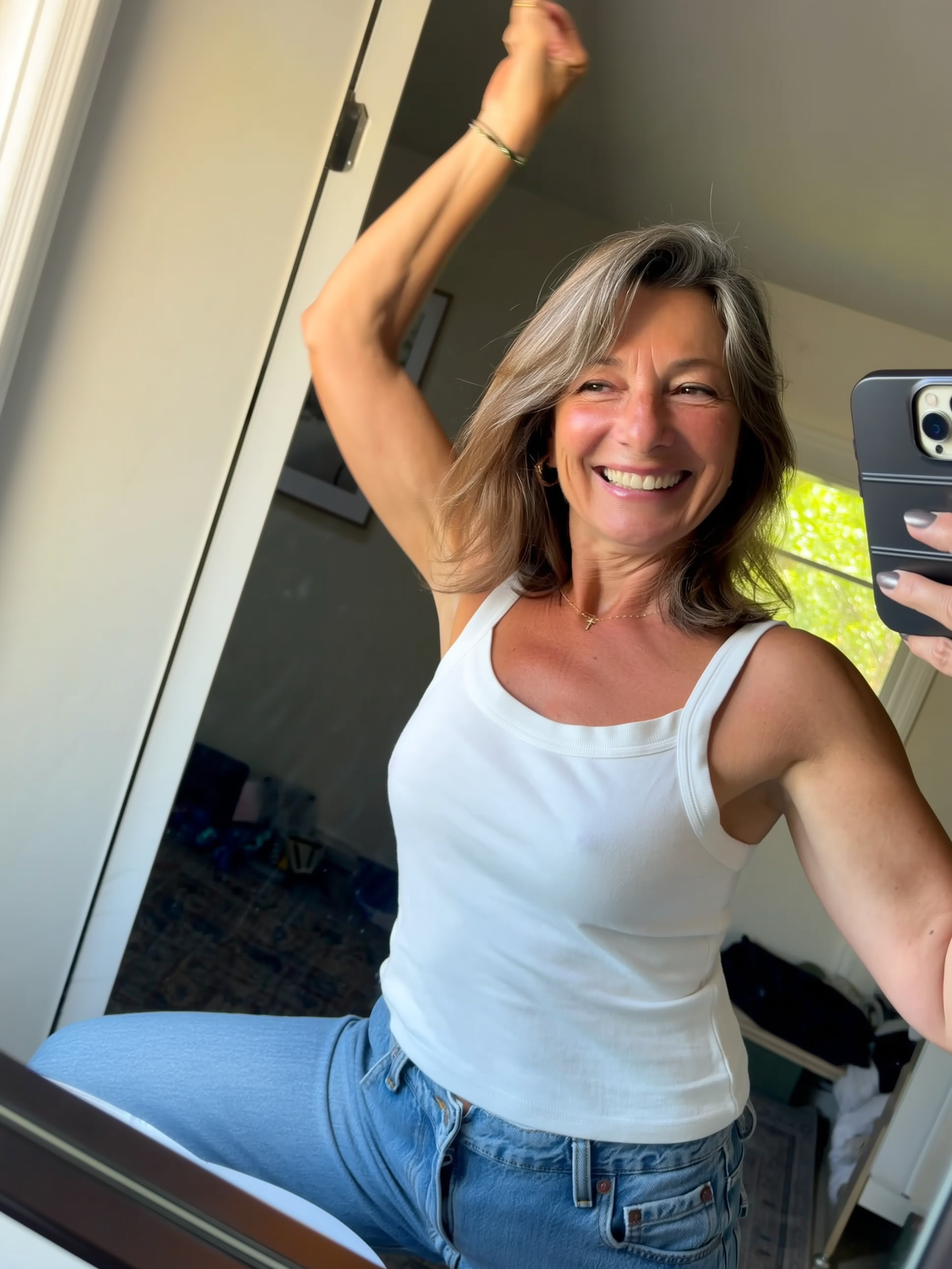 Person taking a smiling selfie in a mirror.