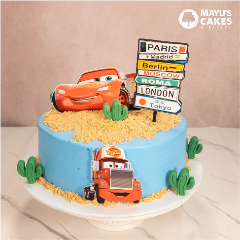 Blue cake with cartoon car toppers and city signpost decorations.