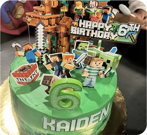 Minecraft-themed birthday cake with characters and 'Happy Birthday 6th' topper.