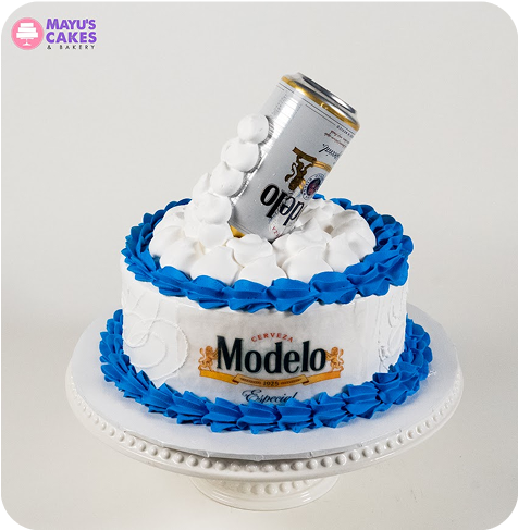 Cake with a beer can on top, decorated with blue and white icing.