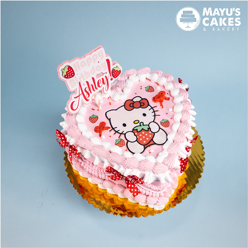 Heart-shaped cake with Hello Kitty design and 'Happy Birthday Ashley' topper.