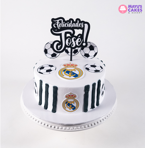 Soccer-themed cake with 'Felicidades José' topper and Real Madrid logos.