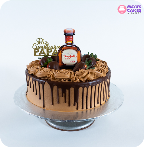 Chocolate cake with a bottle of Don Julio and strawberries on top.
