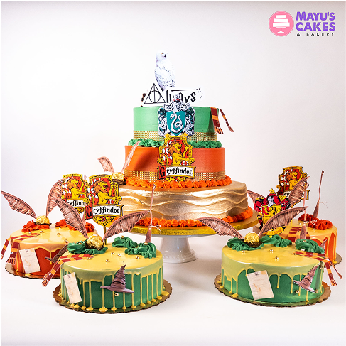 Colorful Harry Potter-themed cakes with house crests and decorations.