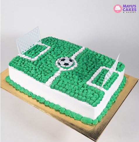 Rectangular cake decorated as a soccer field with goals and a ball on top.