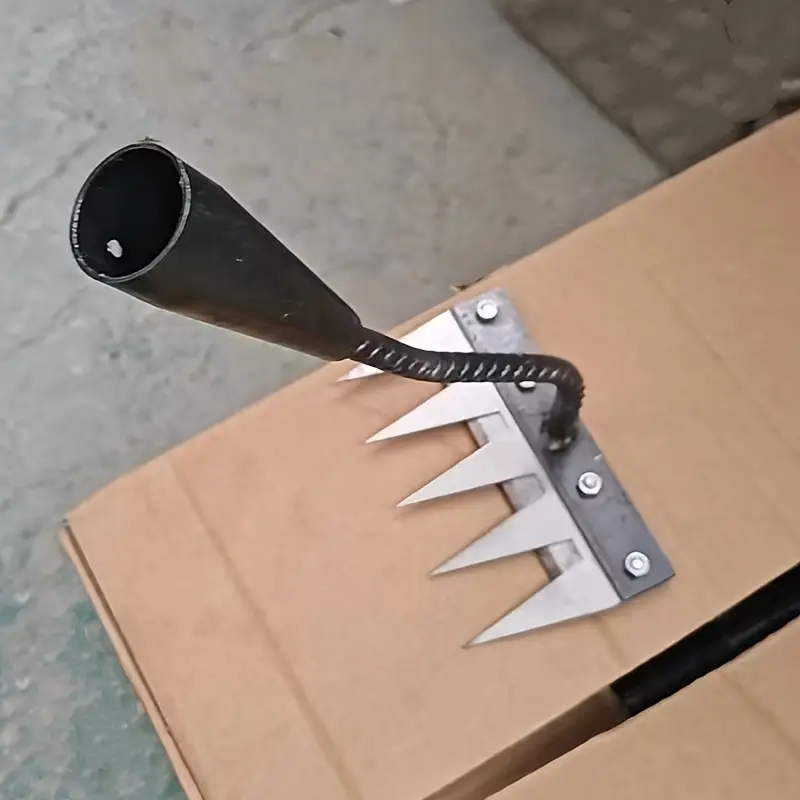 Close-up of a metal tool with jagged prongs and bolt attachments.