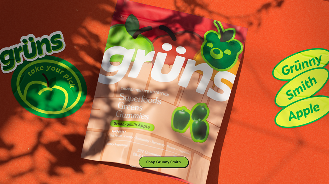 Packaging of Grünny Smith apple gummies on orange background with stickers.