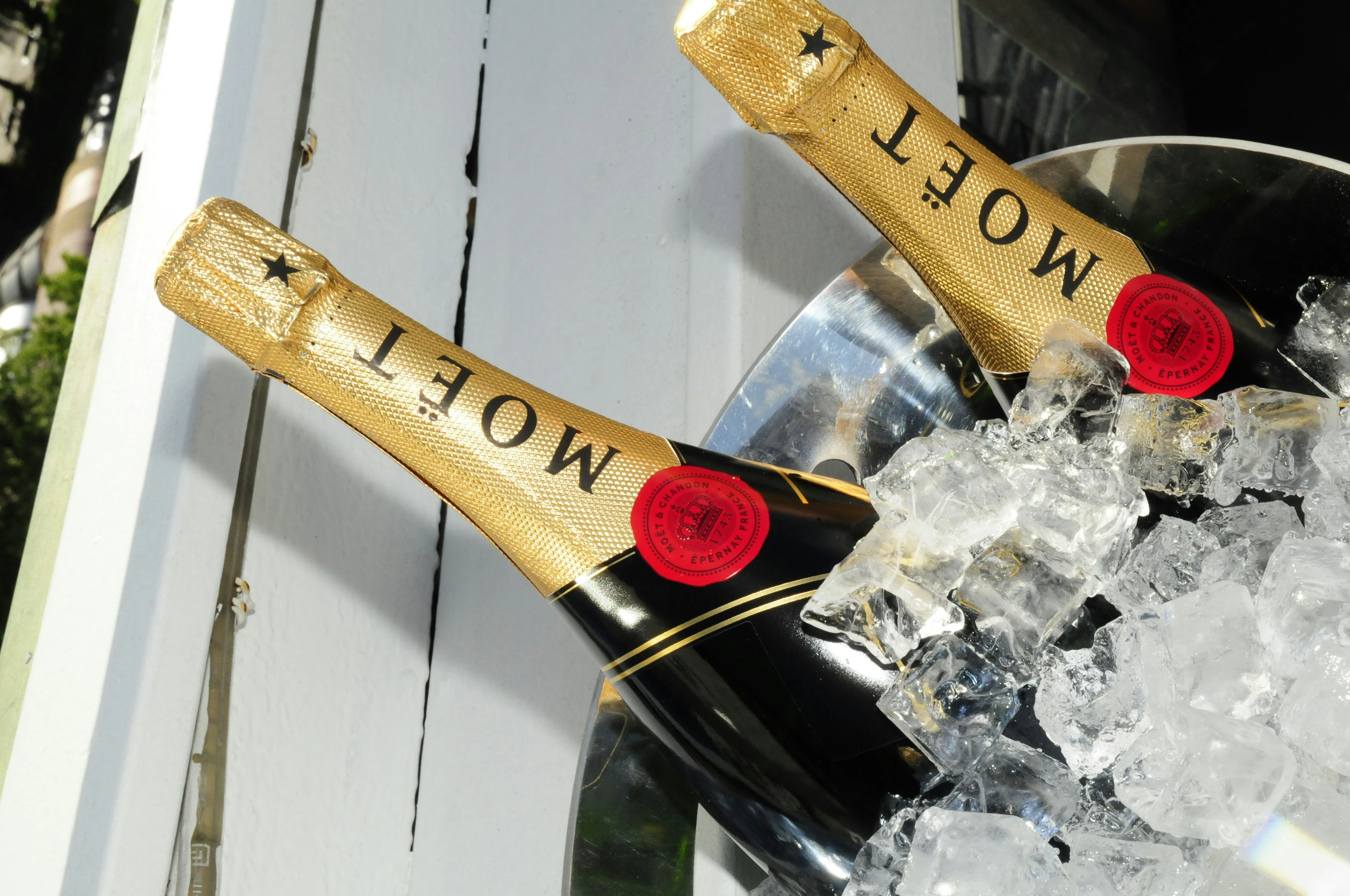 Two bottles of Moët & Chandon champagne chilling in a silver bucket filled with ice.