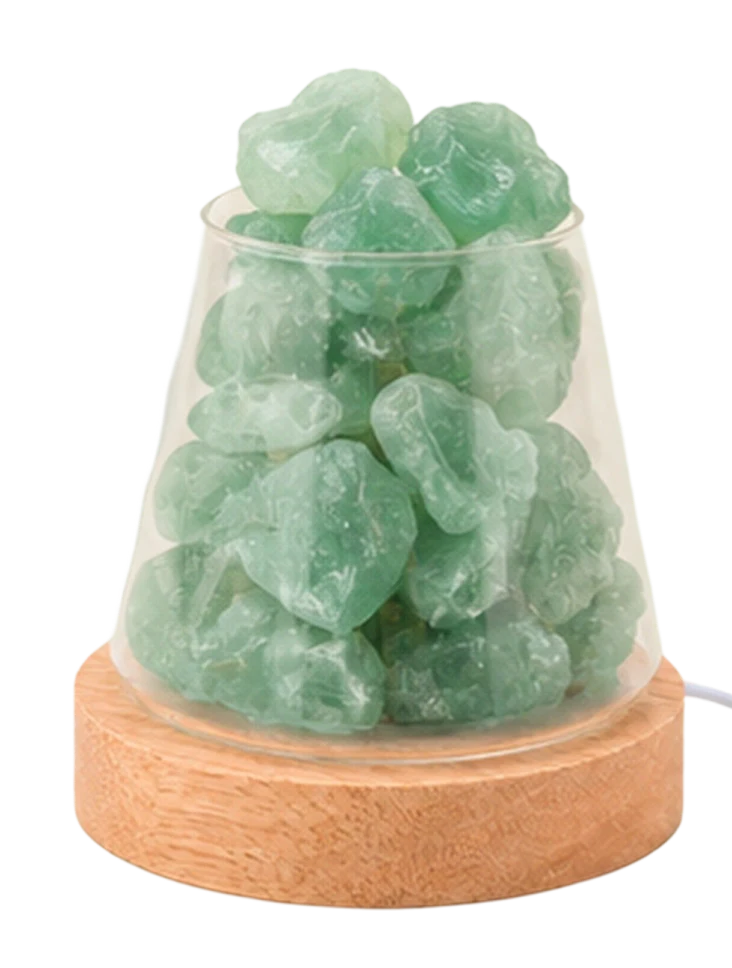 A decorative lamp with a light wood base and a glass vessel filled with rough green stones.