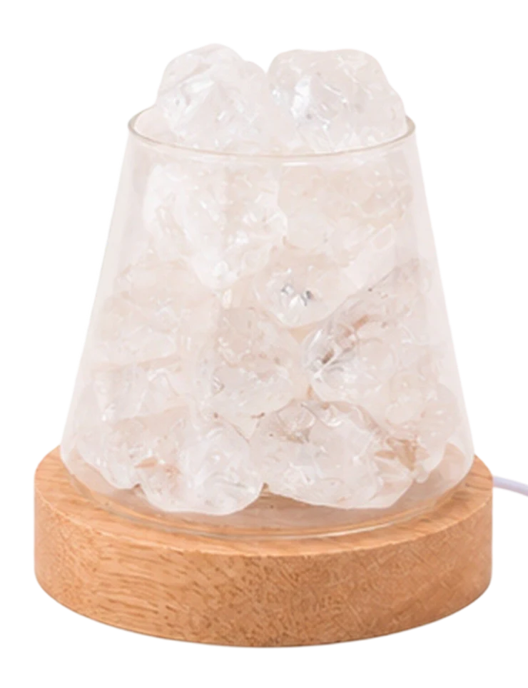 A salt lamp with white crystals in a clear glass container on a light wood base.