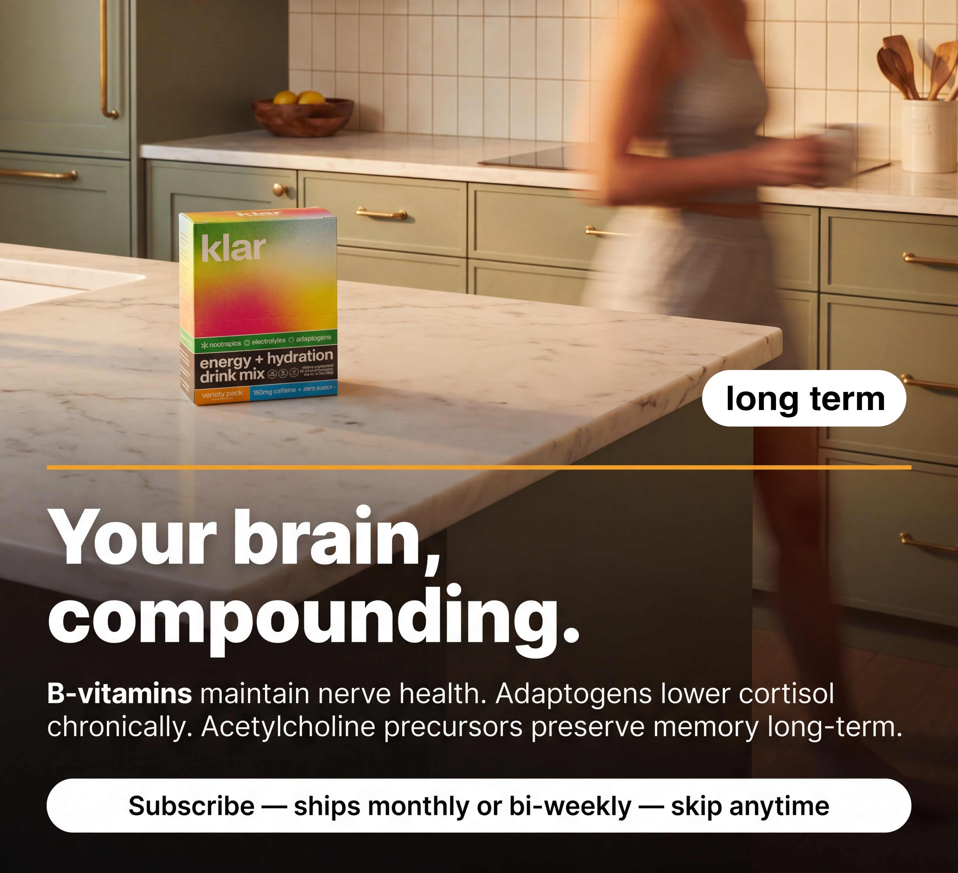 A box of Klar energy drink mix on a marble kitchen counter, with a person blurred in the background.