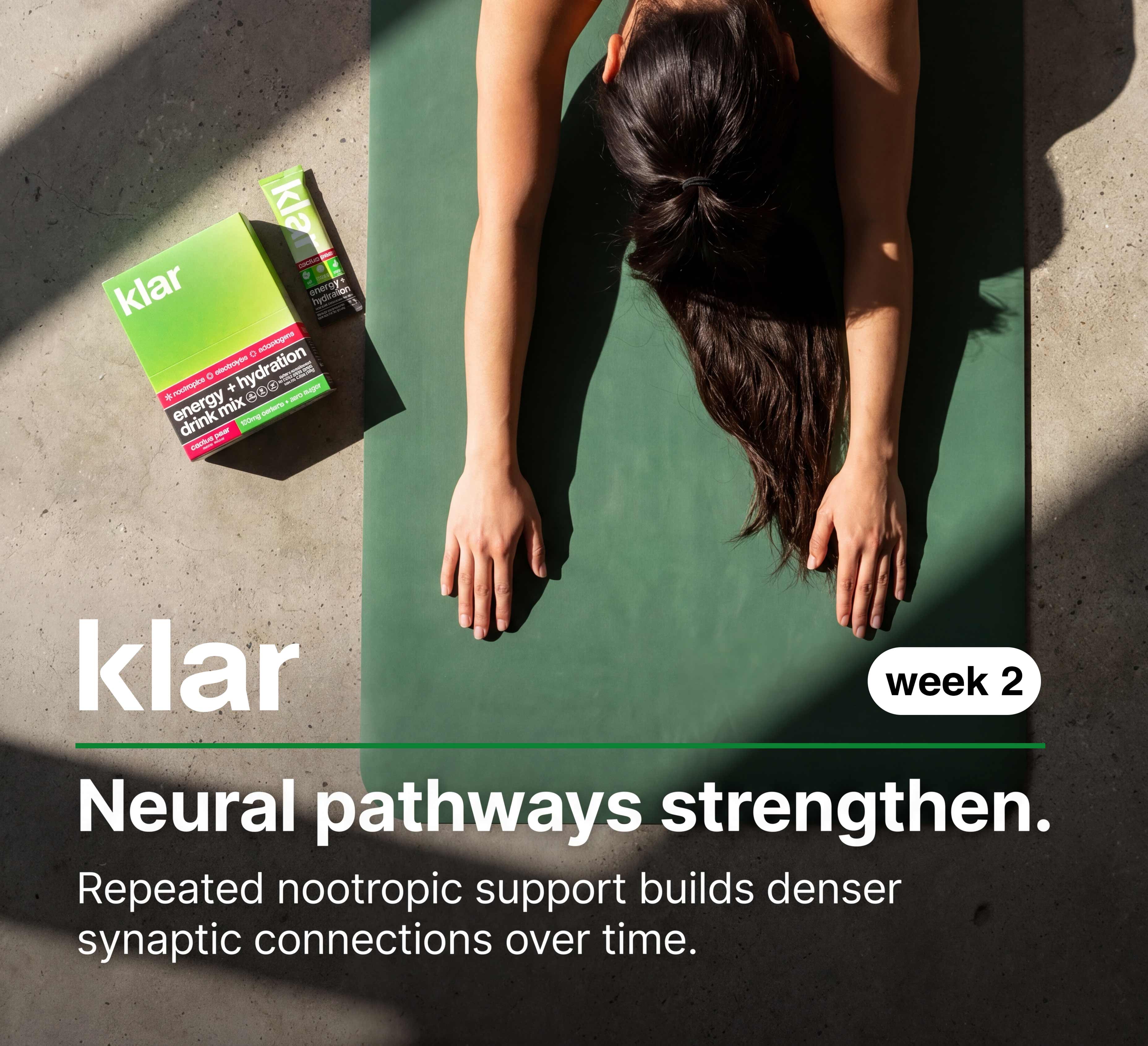 An overhead shot of a woman on a yoga mat next to a box of Klar drink mix.