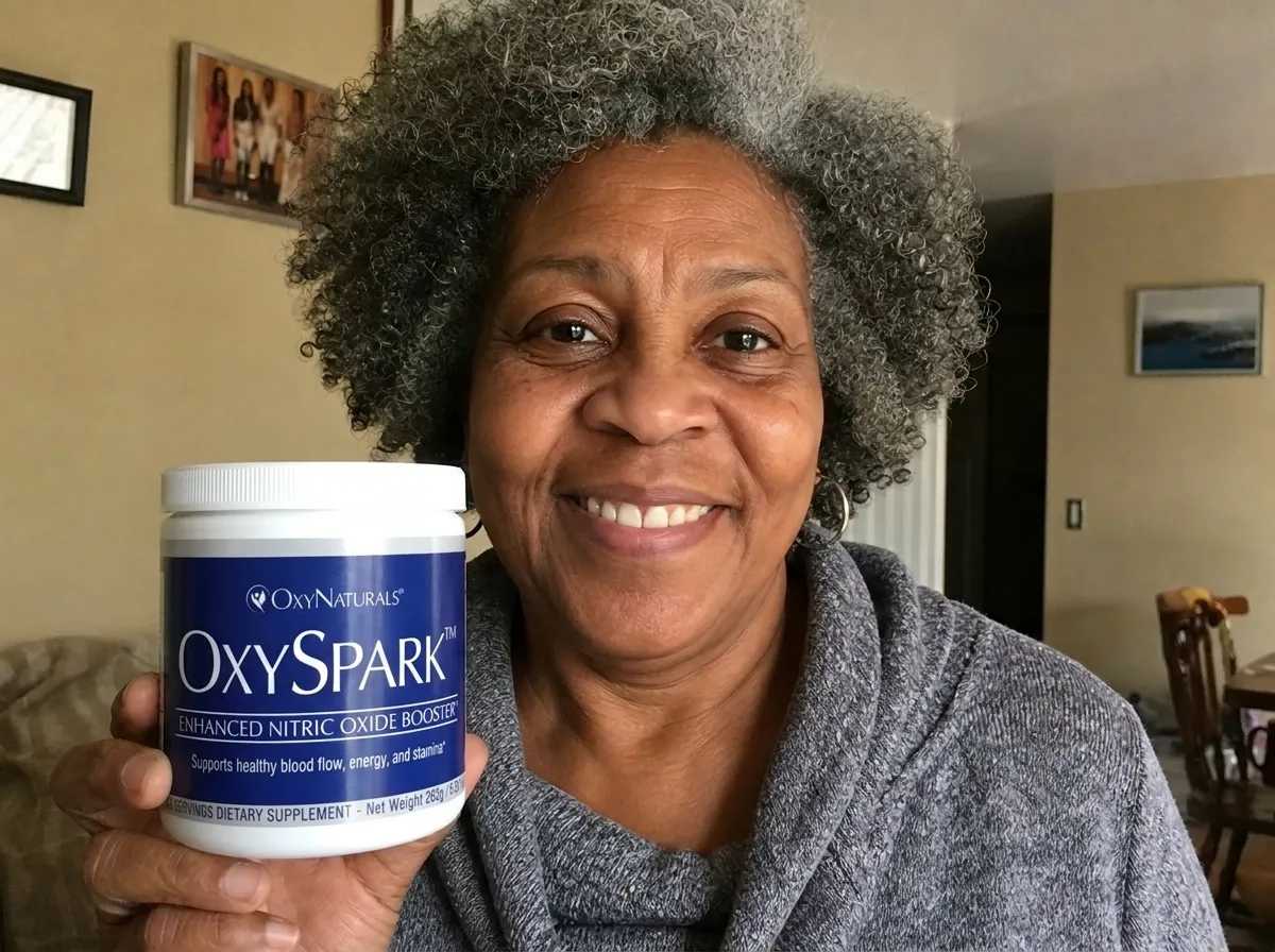 A smiling woman with gray, curly hair holds up a white jar of OxySPARK dietary supplement.