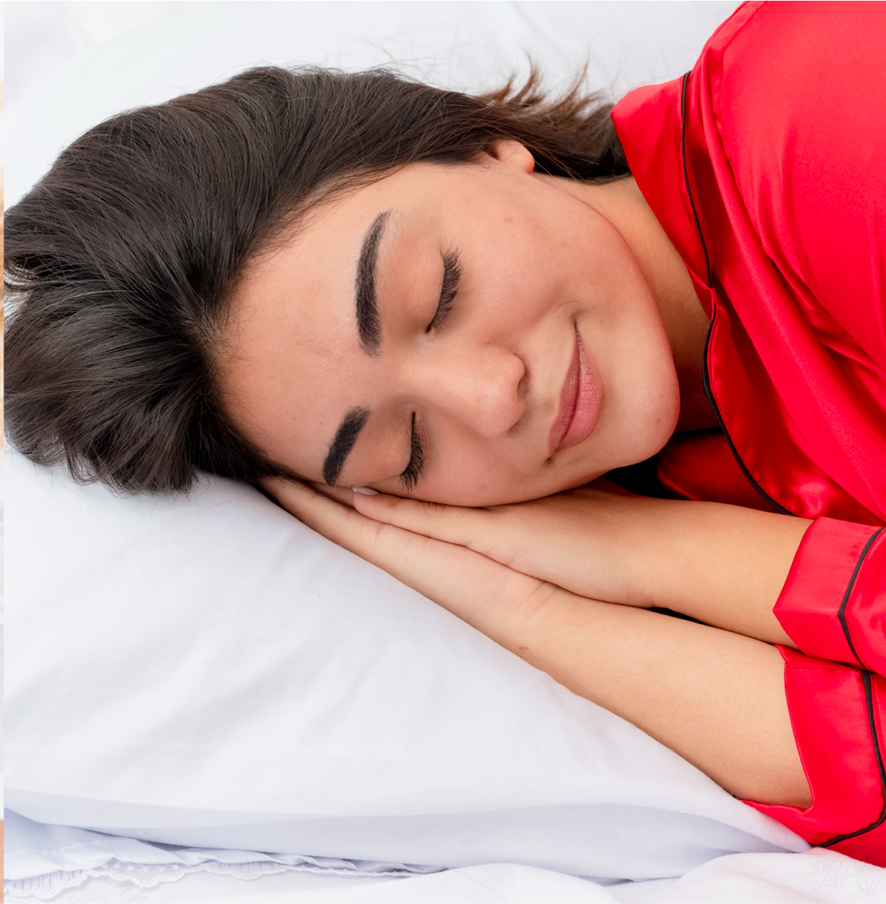 Person sleeping peacefully on a white pillow, wearing a red shirt.