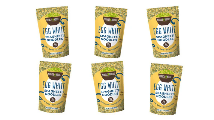 Six packages of egg white spaghetti noodles on a white background.