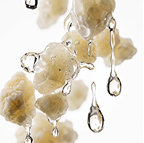A close-up of pale, lumpy solids with clear liquid dripping off them against a white background.