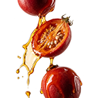 Three red tamarillo fruits, one sliced open, with a golden liquid splashing over them against a white background.
